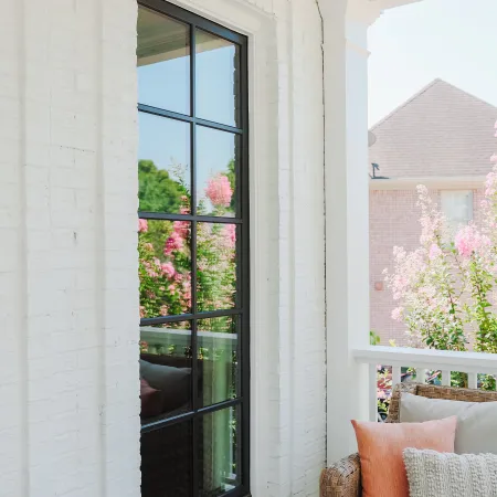 Black casement window with grid as viewed from the porch