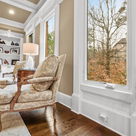 Large white casement window in beautiful living room overlooking trees