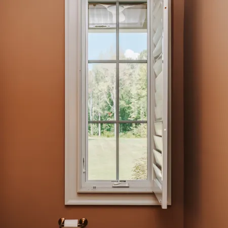 A narrow casement window in a bathroom