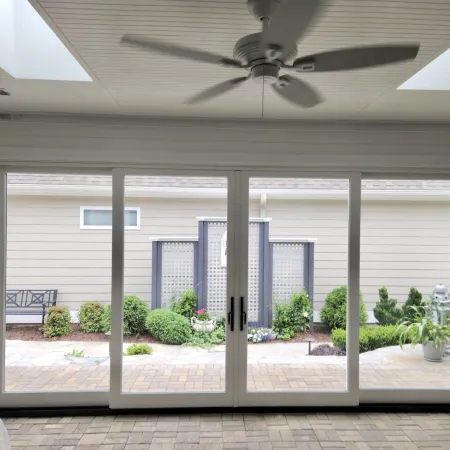 A white sliding glass door connects indoor and outdoor living spaces