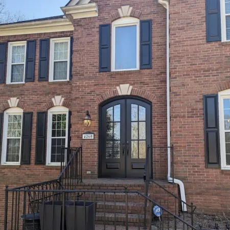 Brick house with black arched double French doors