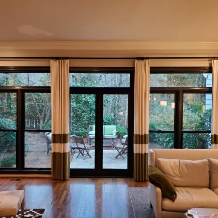 A living room with black French Doors leading onto back patio