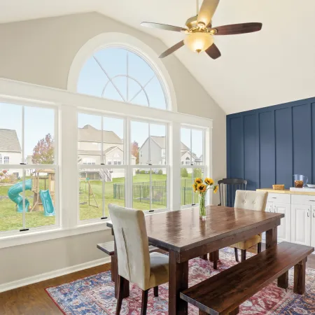 a dining room with a large window and round top transom