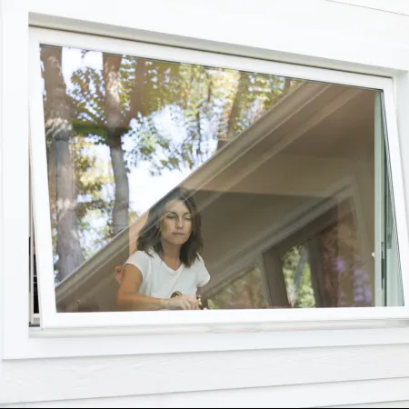 A woman opening a white awning window