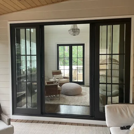 a room with a glass door and a couch and a chair