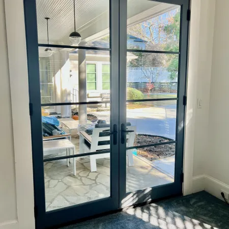 Modern fiberglass double patio doors with black frame and glass leading to backyard