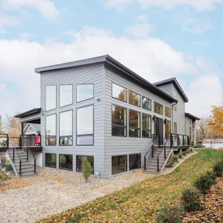 A gray house with square and custom shape picture and awning windows