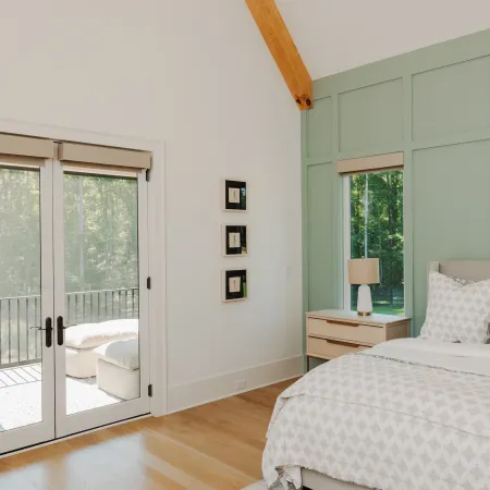 Bedroom with white fiberglass French doors leading to balcony.