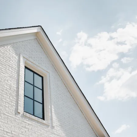 White brick house with black fiberglass casement window with black grids installed by North Georgia Replacement Windows