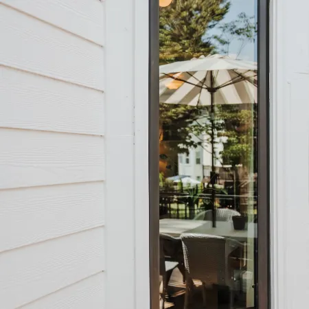 Oil rubbed bronze casement window installed on a white home with white siding