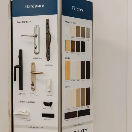 Display board showcasing door and window hardware with various finishes for Infinity replacement windows.