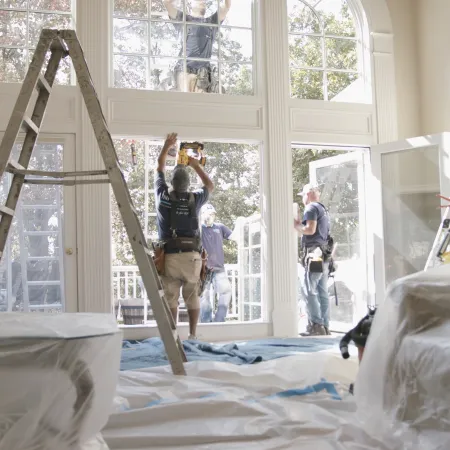 a group of people standing in a room with ladders and windows