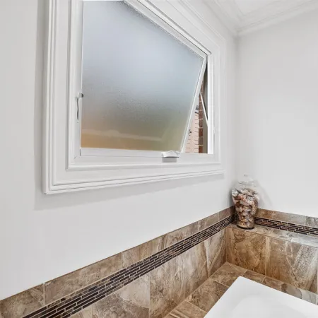 a bathroom with a window with privacy glass
