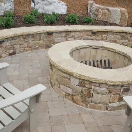 a stone fireplace with chairs around it