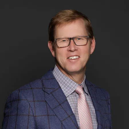 a man wearing glasses and a suit