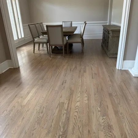 Dining room with wooden table, six chairs, hardwood floor, beige walls, chandelier, and sideboard.
