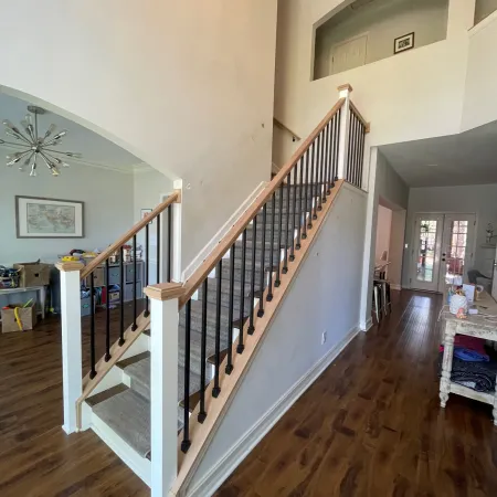 Modern home interior with carpeted stairs, wooden flooring, and open living space with natural light.