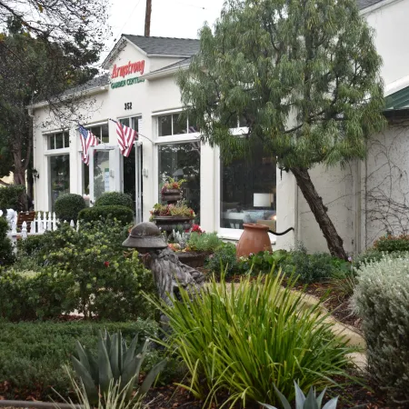 Front view of Armstrong Garden Center with American flags and lush greenery in the garden area