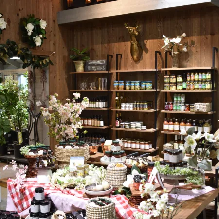 Cozy pantry with wooden shelves, jars, bottles, flowers, and glowing marquee PANTRY sign overhead.