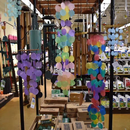 Colorful wind chimes hanging on display rack with Woodstock Chimes sign in a store aisle.