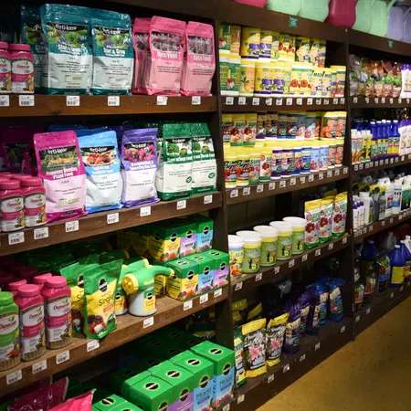 Store shelves stocked with various garden fertilizers, plant food, seeds, and plant care products.