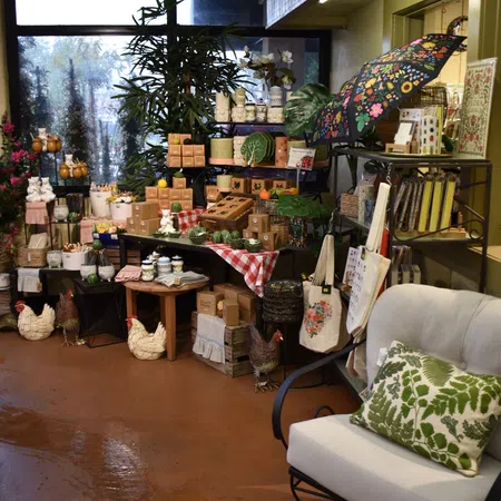 Cozy indoor display of decorative plants, ceramic chickens, tableware, and floral-themed home decor items.