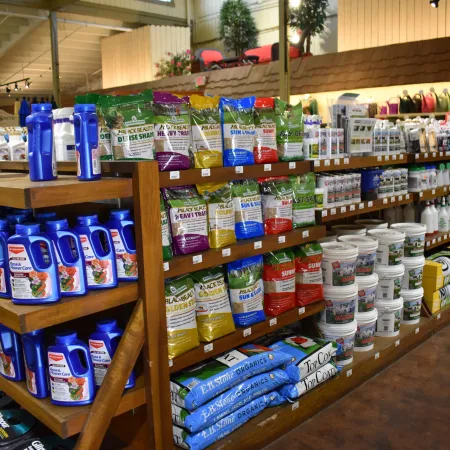 Store shelves displaying gardening supplies including fertilizers, plant food, soil, and plant care products.