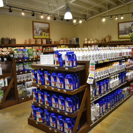 Shelves in a garden store stocked with various gardening products including fertilizers and plant care items.