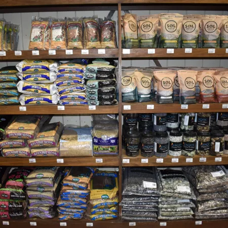 Shelves stocked with various gardening soils, fertilizers, and organic amendments in bags and containers.