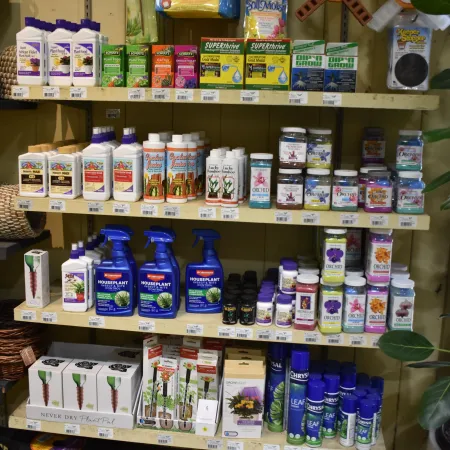 Shelves stocked with various plant care products including fertilizers, sprays, soil moisture packs, and plant food bottles.