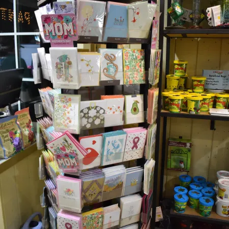 Mother's Day greeting cards on display rack in a store with floral and heart designs