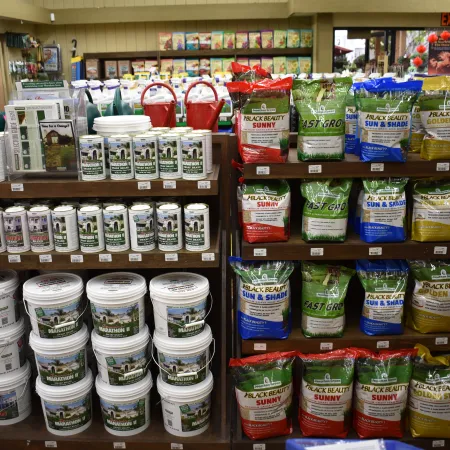 Shelves stocked with various gardening products including plant fertilizers, soil, and gardening supplies in a store.