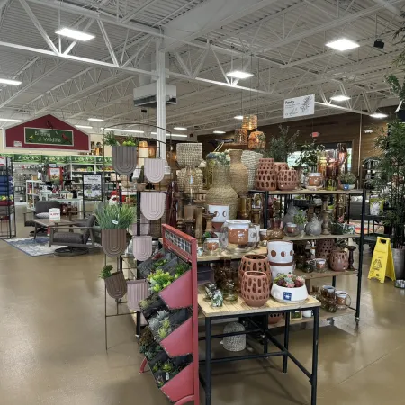 Indoor garden center displaying various decorative pots, planters, and garden accessories on shelves and tables.