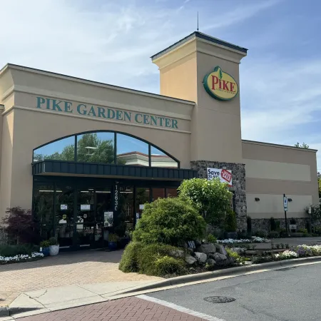 Exterior view of Pike Garden Center building with landscaping and clear blue sky above.