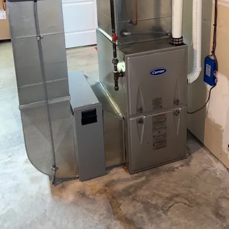 Residential Carrier HVAC furnace system with ductwork and vent pipes installed in basement