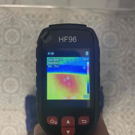 Handheld HF96 thermal camera displaying a color heat map with temperature readings from 75.5°F to 84.9°F.