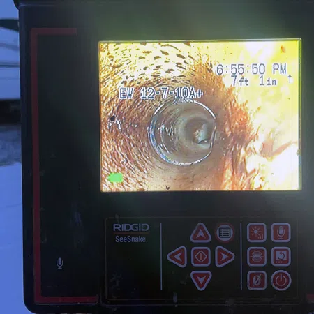 RIDGID SeeSnake inspection camera screen showing inner pipe view with measurement and timestamp.
