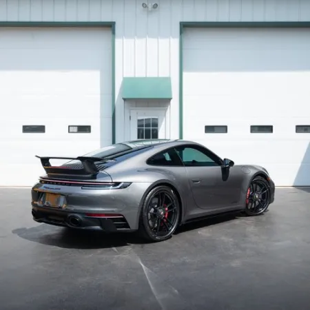 a silver sports car parked in front of a garage