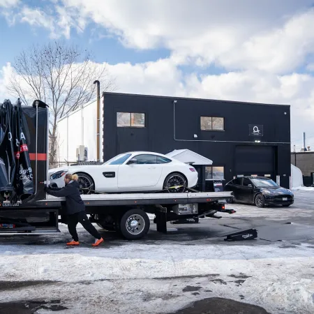 a person pushing a car on a trailer