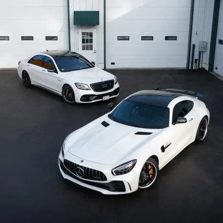 two white cars parked in a garage