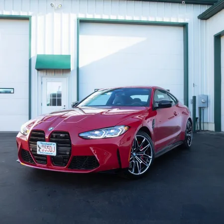 a red car parked in front of a garage