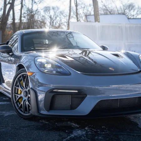 a silver sports car parked on a road with snow on the side