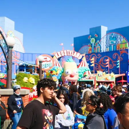 Crowd enjoying sunny day at vibrant Krustyland amusement park with colorful rides and cartoon-themed attractions