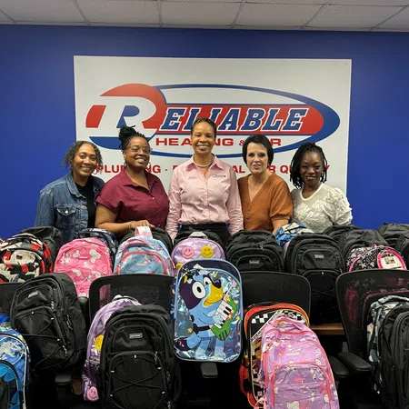 Grace Jackson et al. pose for a photo next to a pile of luggage