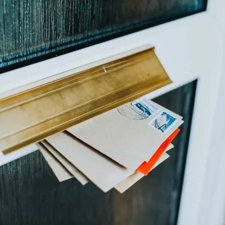 a stack of letters inside a door mail slot