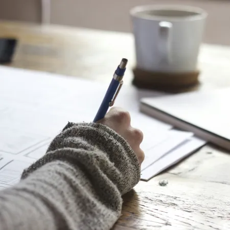 a person writing on a piece of paper