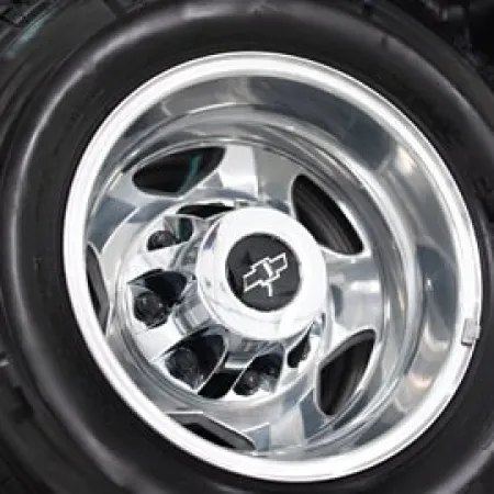 Close-up of a chrome car wheel rim with a Chevrolet logo on a black tire.
