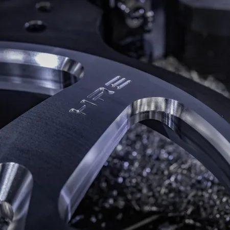 Close-up of a shiny metal component with engraved numbers, showing detailed machining and smooth finishes.