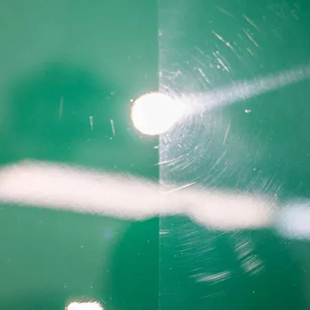 Before and after image showing scratched and polished green glass surface under bright lighting.