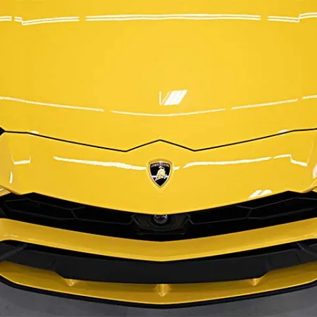 Close-up front view of a yellow Lamborghini sports car showcasing headlights and emblem on hood.